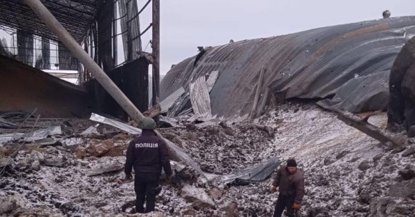 A police officer and a local worker inspect the destroyed grain storage in Vovchansk, Kharkiv region, after russia's attack with two guided bombs on Jan 14, 2024