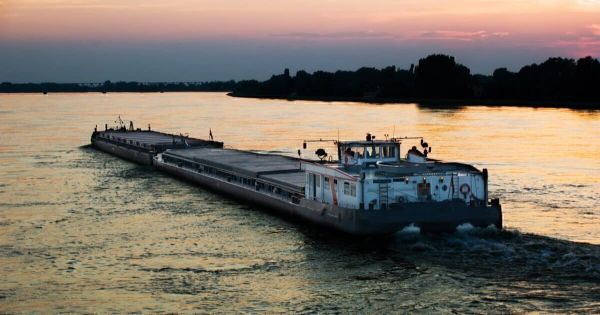 A barge loaded with farm products moves along the Danube