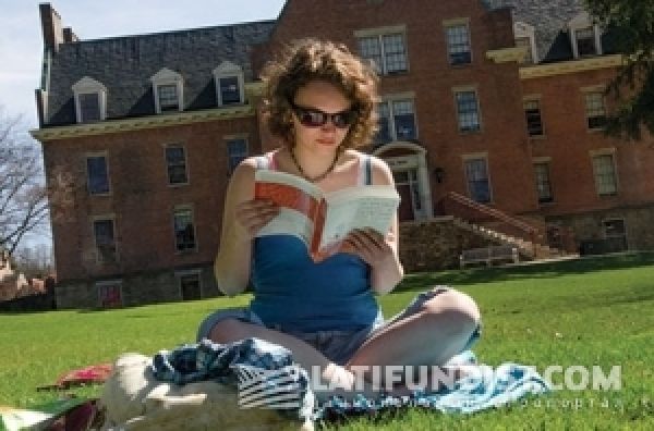 Девушка читает книгу на лужайке, alfred.edu