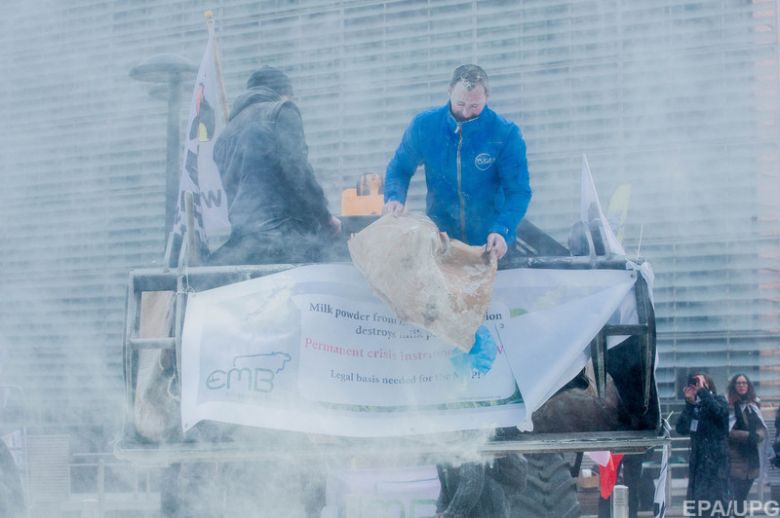 European Milk board (EMB) representatives spray milk powder in front of the EU Council headquarters