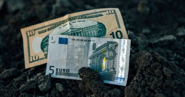 10-dollar bill and 5 euro note in Ukraine's black soil