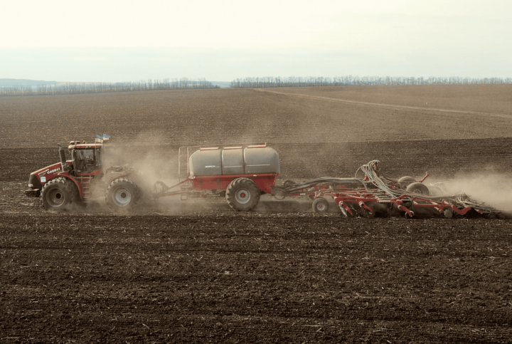 A HORSCH seed drill towed to a CASE IH tractor is planting spring crops in CFG field in Ukraine. March 2023