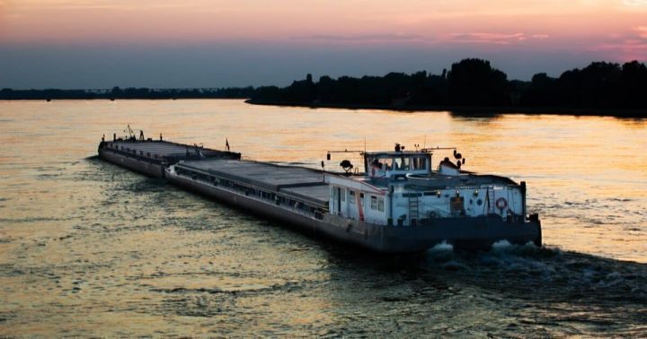 A barge loaded with farm products moves along the Danube