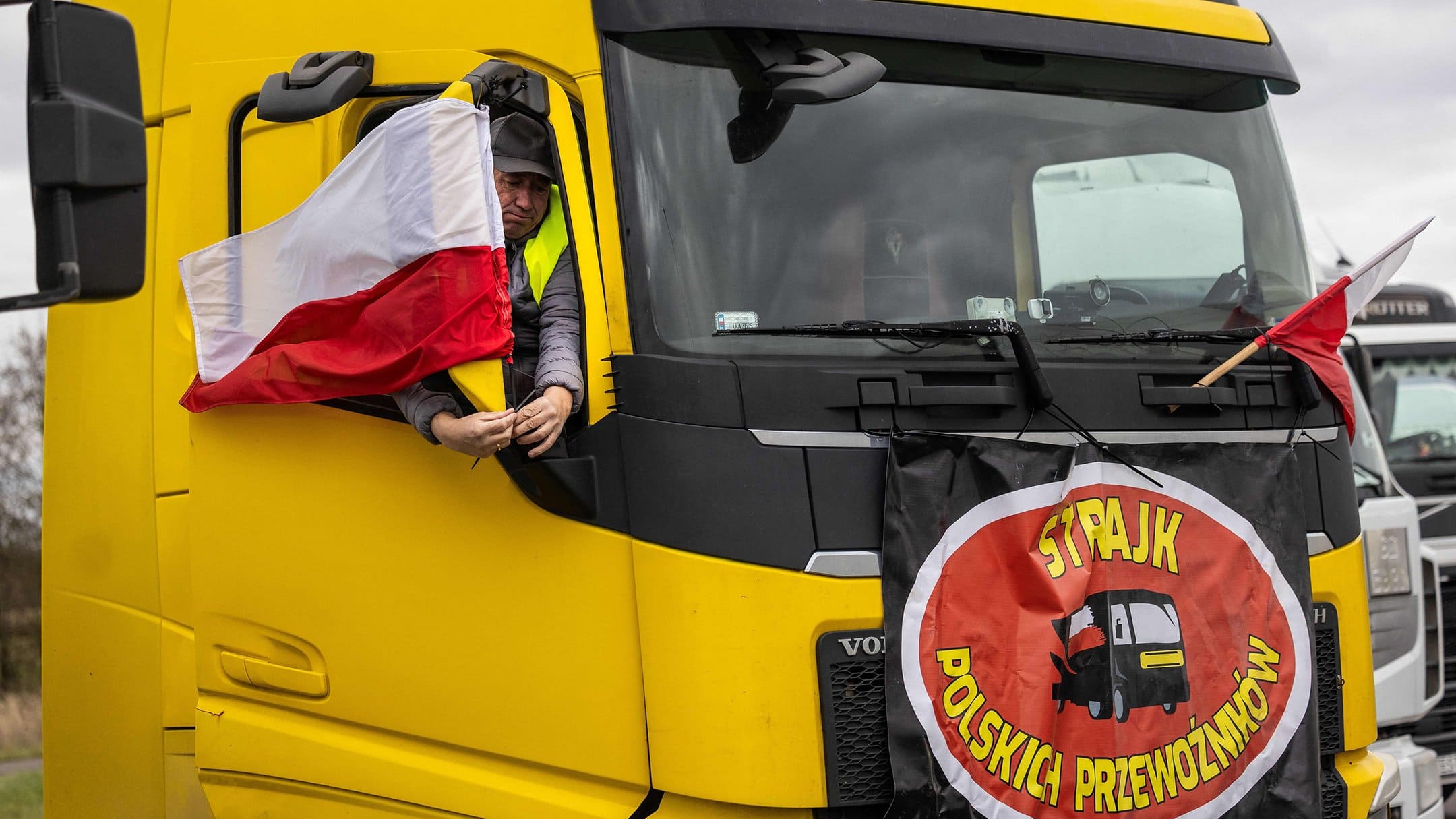 Польський учасник акції прикріплює прапори та банери на свій транспорт поблизу Дорогуська. Фото: Wojtek Radwanski/AFP/Getty Images
