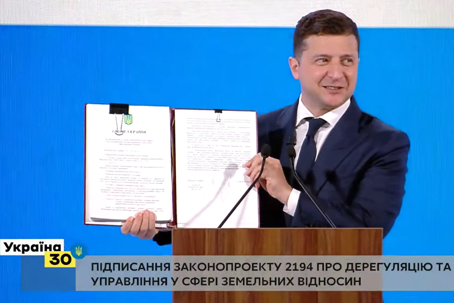 President of Ukraine Volodymyr Zelenskyy holding the newly signed law On Amending the Land Code of Ukraine and Other Laws on Improving Administration System and Land Relation Deregulation